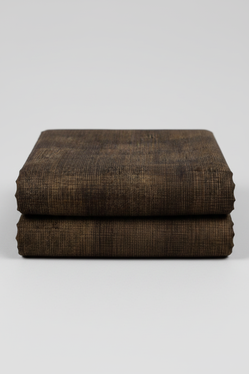 Folded Interwoven Bark quilting cotton fabric on a light grey background – by Jason Yenter for In The Beginning Fabrics. Shop at IraRobi Quilts | #barkfabric #interwoven #quiltingfabric #darkfabric #blenderfabric