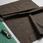 Very dark brown quilting cotton fabric in a bright modern sewing room with cutting mat and rotary cutter – Interwoven Bark by Jason Yenter. Shop at IraRobi Quilts | #barkfabric #interwoven #quiltingstudio #sewingroom #quiltingfabric