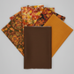 Interwoven Brown Fabric by Jason Yenter for In The Beginning Fabrics stacked with coordinating autumn fabrics – medallion leaves, packed autumn leaves, dense leaves and berries, and golden-amber crosshatch. Perfect for fall and Thanksgiving quilts. Shop at IraRobi Quilts | #brownfabric #interwoven #autumnquilt #fallquilt #quiltingfabric #fabricstack #thanksgivingquilt