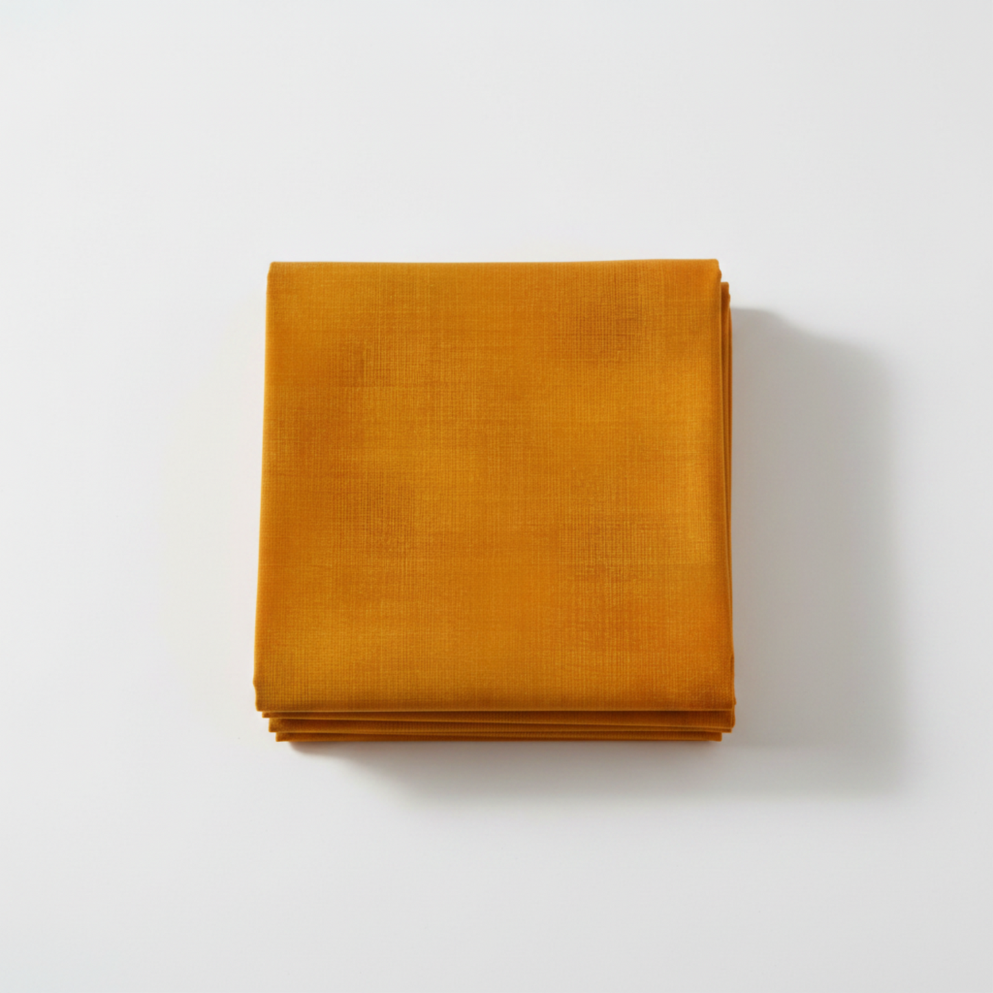 Interwoven Butterscotch Fabric by Jason Yenter for In The Beginning Fabrics — neatly folded fat quarter stack showing warm golden amber crosshatch texture print with subtle tonal shifts to deep caramel-brown. Clean white surface, soft natural light. 100% cotton, 43–44" wide.