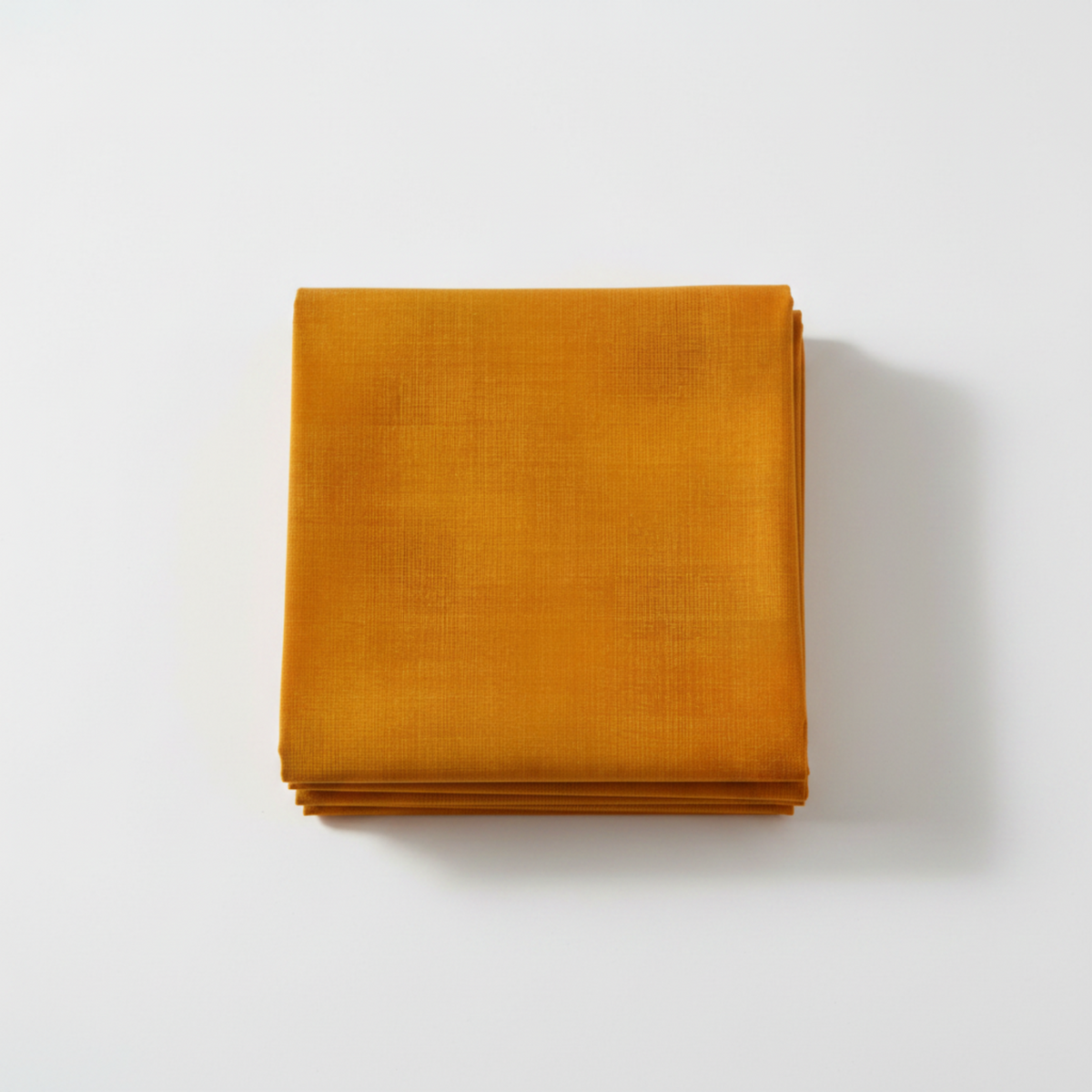 Interwoven Butterscotch Fabric by Jason Yenter for In The Beginning Fabrics — neatly folded fat quarter stack showing warm golden amber crosshatch texture print with subtle tonal shifts to deep caramel-brown. Clean white surface, soft natural light. 100% cotton, 43–44" wide.