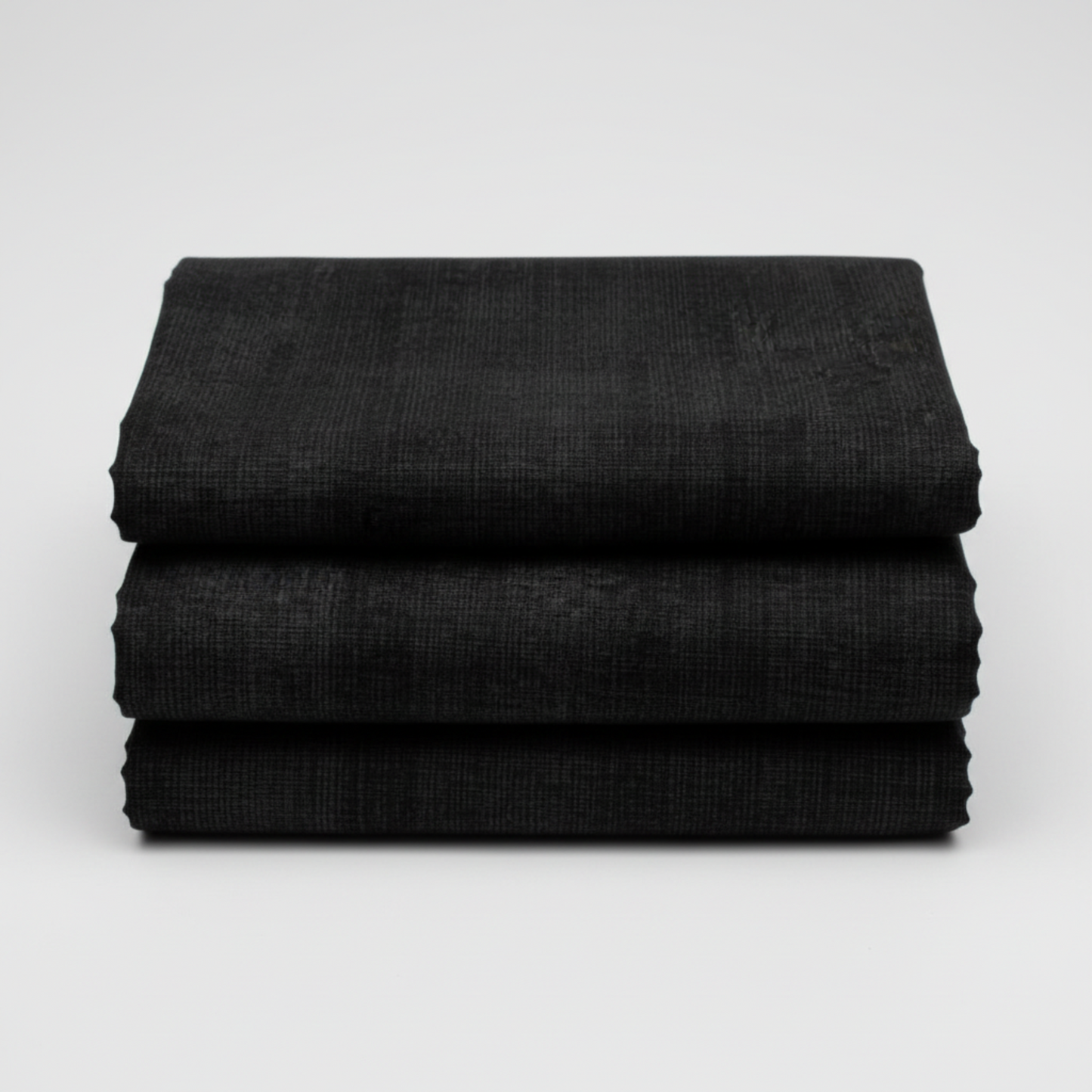 Interwoven Charcoal quilting cotton fabric folded to show the deep grey-black geometric crosshatch print and texture – by Jason Yenter for In The Beginning Fabrics