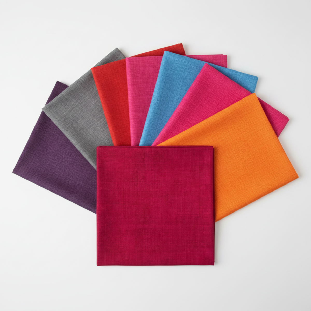 Interwoven coordination fan CherryInterwoven Cherry Fabric by Jason Yenter for In The Beginning Fabrics fanned alongside coordinating Interwoven colorways — all sharing the same fine crosshatch texture print in vivid saturated tones. Versatile tonal blenders for modern and rainbow quilts. 100% cotton, 43–44" wide.