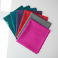 Interwoven Pink Fabric by Jason Yenter for In The Beginning Fabrics fanned alongside other Interwoven colorways — all sharing the same fine crosshatch texture print in vivid saturated tones. Versatile tonal blenders for modern and rainbow quilts. 100% cotton, 43–44" wide.