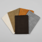 Interwoven Espresso Fabric by Jason Yenter for In The Beginning Fabrics fanned with coordinating crosshatch fabrics in taupe, olive, butterscotch, and pewter