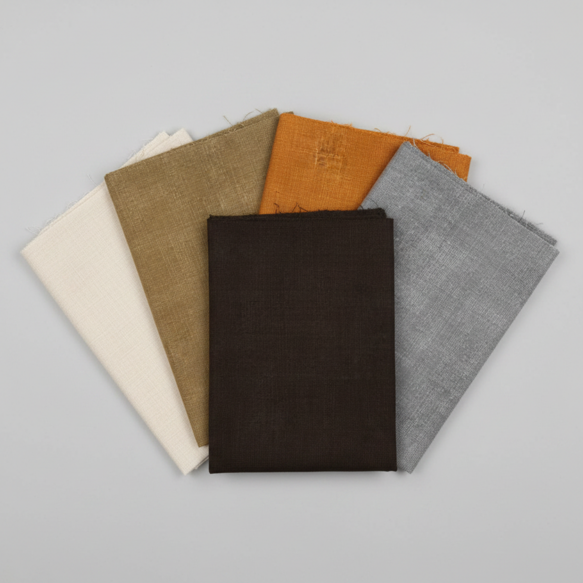 Interwoven Espresso Fabric by Jason Yenter for In The Beginning Fabrics fanned with coordinating crosshatch fabrics in taupe, olive, butterscotch, and pewter