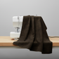 Interwoven Espresso Fabric by Jason Yenter for In The Beginning Fabrics draped over a sewing machine with soft natural folds showing the near-black espresso brown geometric crosshatch print