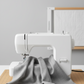 Cool medium grey quilting cotton fabric draped over a sewing machine in a clean quilting studio – Interwoven Pewter by Jason Yenter for In The Beginning Fabrics. Shop at IraRobi Quilts | #pewterfabric #interwoven #quiltingfabric #greyfabric #modernquilt