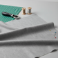 Cool grey quilting cotton fabric in a bright modern sewing room with cutting mat, rotary cutter, thread spools, and pins – Interwoven Pewter by Jason Yenter. Shop at IraRobi Quilts | #pewterfabric #interwoven #quiltingstudio #sewingroom #quiltingfabric