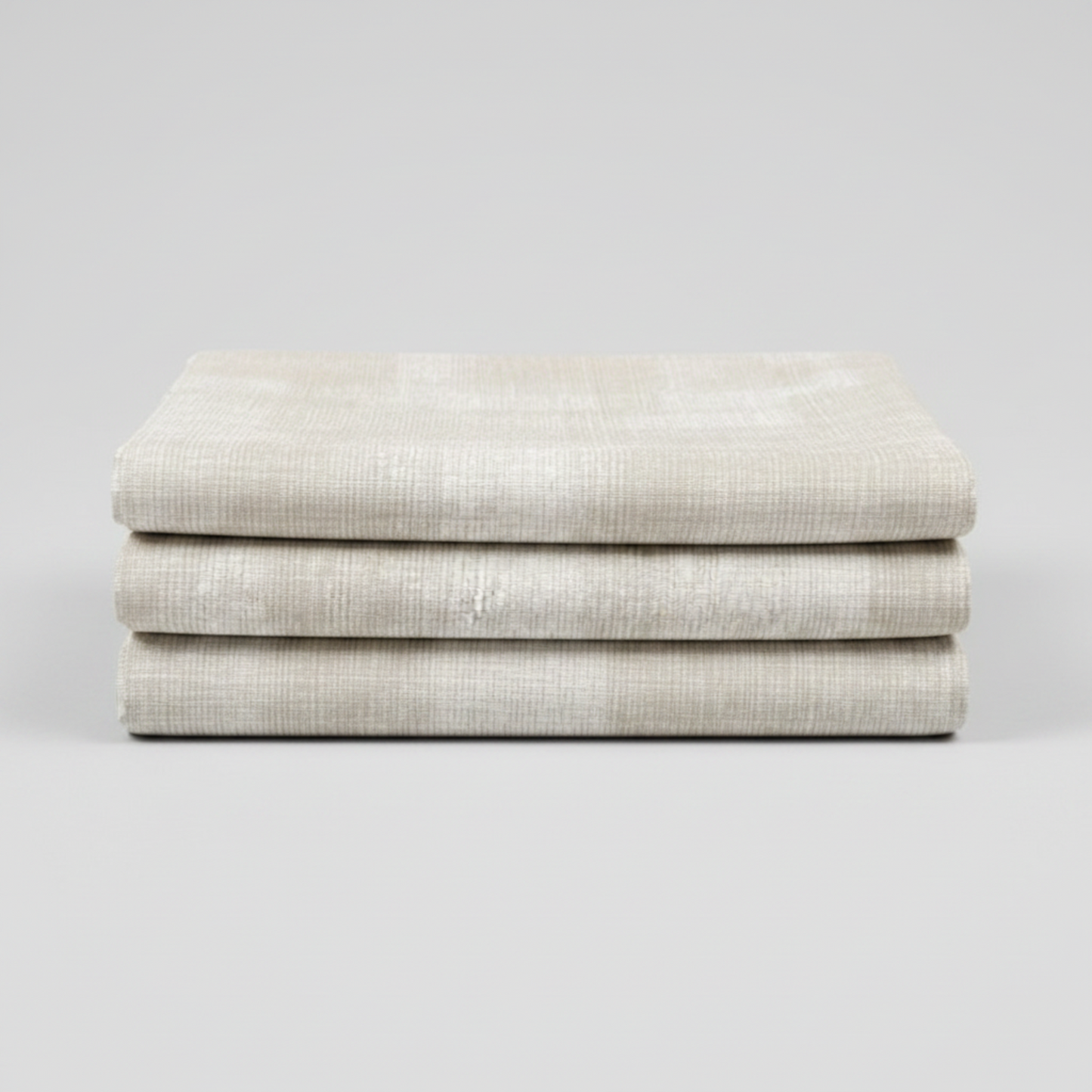Interwoven Taupe Fabric by Jason Yenter for In The Beginning Fabrics — soft cream and taupe linen-look crosshatch blender quilting cotton neatly folded showing pattern detail, raw cut edges, light grey background, 100% cotton, 43–44" wide