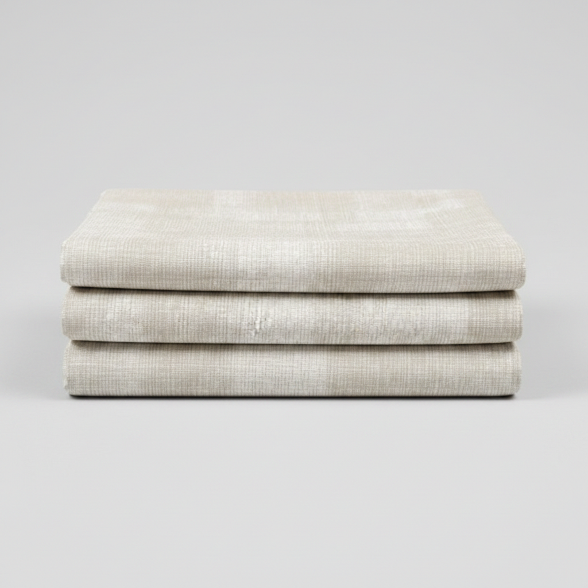 Interwoven Taupe Fabric by Jason Yenter for In The Beginning Fabrics — soft cream and taupe linen-look crosshatch blender quilting cotton neatly folded showing pattern detail, raw cut edges, light grey background, 100% cotton, 43–44" wide