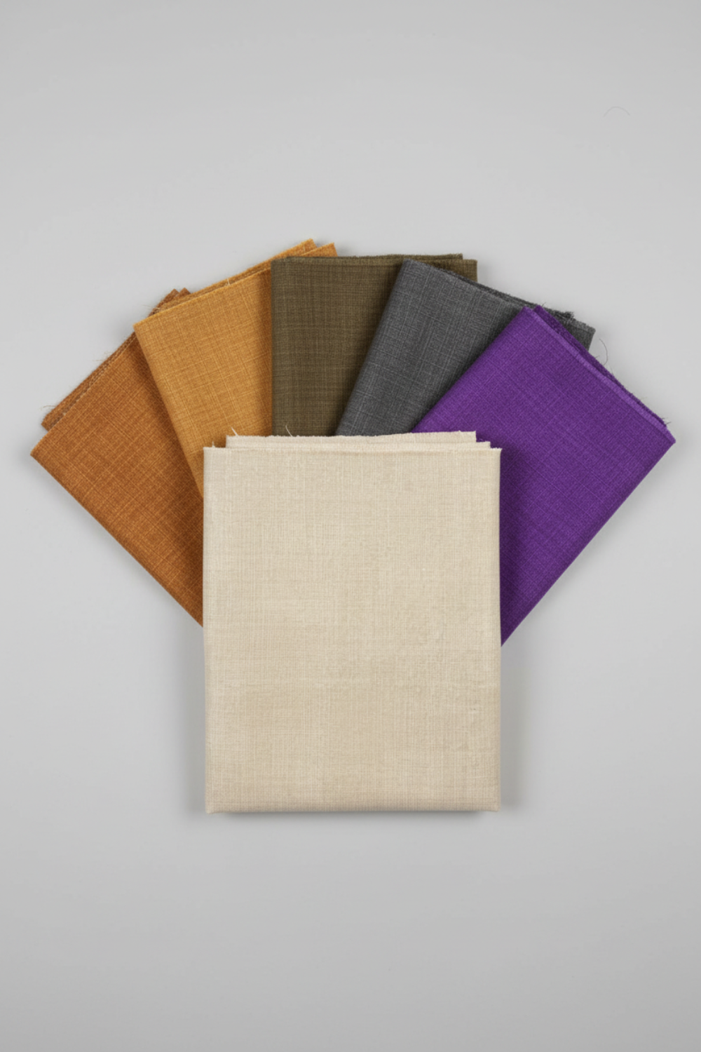 Interwoven Taupe Fabric by Jason Yenter for In The Beginning Fabrics — vertical fan arrangement with coordinating Interwoven Butterscotch, Olive, Slate, and Plum crosshatch quilting cottons on a light grey background, 100% cotton, 43–44" wide