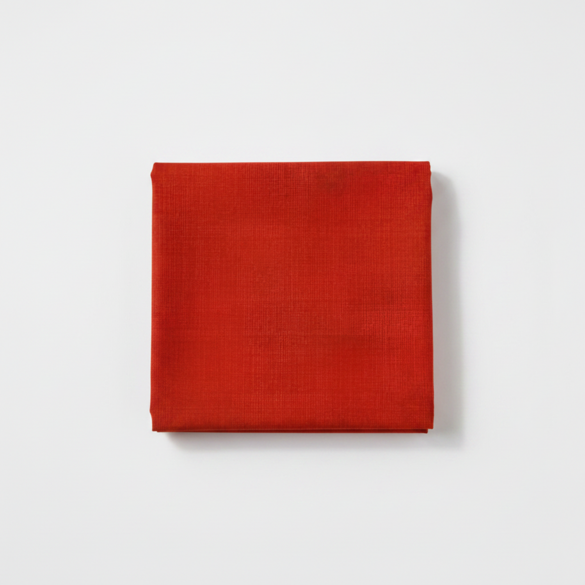 Interwoven Tomato Fabric by Jason Yenter for In The Beginning Fabrics — neatly folded fat quarter showing vivid fire-engine red crosshatch texture with subtle brick-red tonal shifts. Clean white surface, soft natural light. 100% cotton, 43–44" wide.