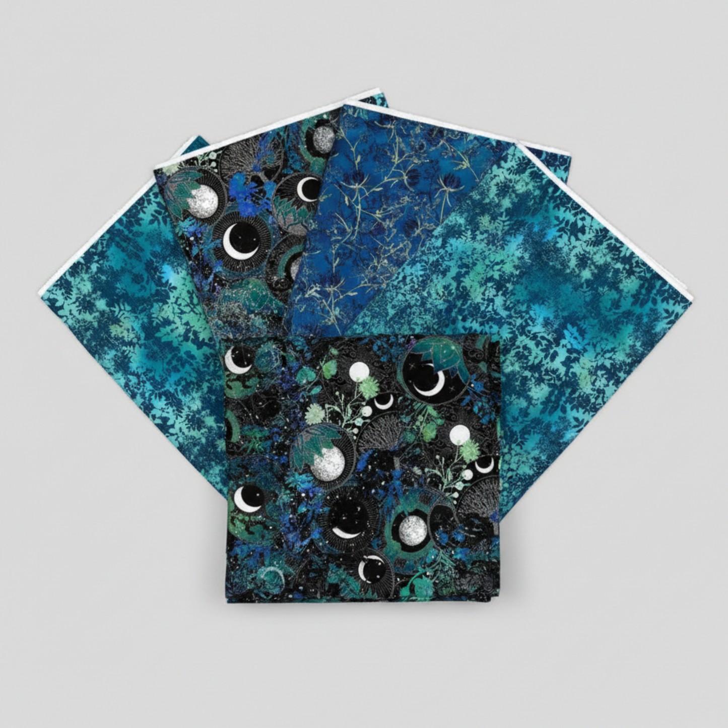 La Luna Black Bursts quilting cotton fabric by Jason Yenter for In The Beginning Fabrics shown in a fan with coordinating La Luna collection fabrics – geometric star burst blender with glowing hexagonal dots in teal, aqua, and chartreuse on deep black, with La Luna Blue Silver Moon Collage, Blue Night Blooms, and Teal Leaves, 100% cotton, 3 yard cuts