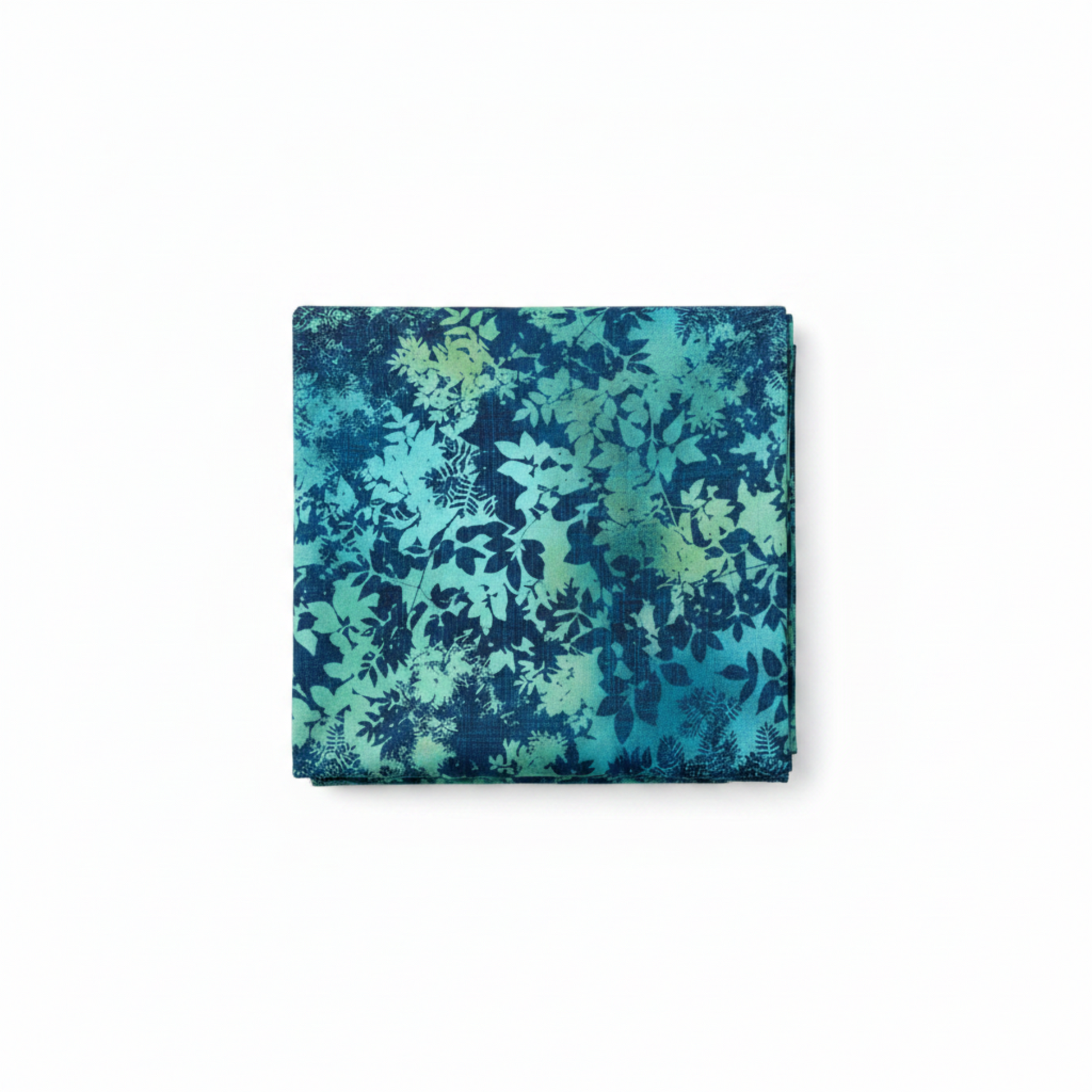La Luna Teal Leaves quilting cotton fabric folded to show dense allover tonal leaf silhouette print – overlapping fern fronds, maple leaves, and botanical sprigs in aqua, teal, chartreuse, and deep navy on rich cobalt and teal watercolor wash by Jason Yenter for In The Beginning Fabrics, 100% cotton, 3 yard cut