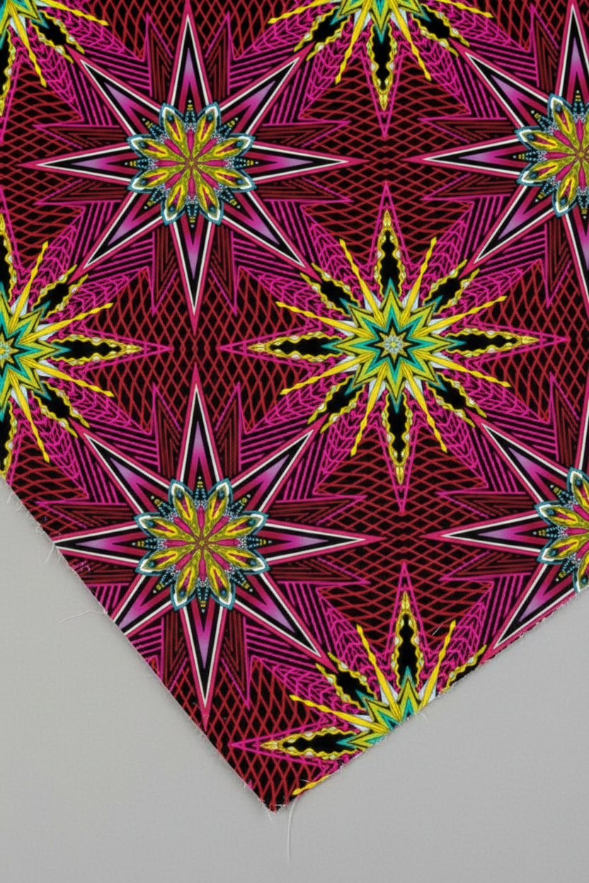What If Radio Star Red/Multi quilting cotton macro detail — intricate kaleidoscopic starburst in magenta, crimson, black, and yellow-gold by Paula Nadelstern for Benartex
