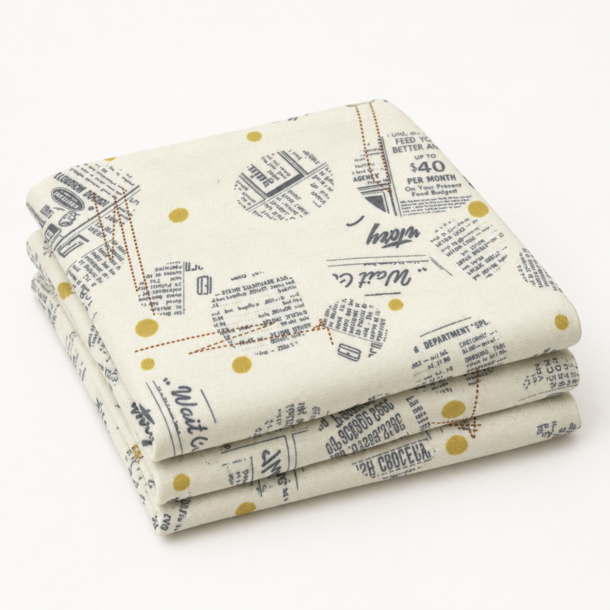 Folded Celestial News Dropping Moonbeam fabric by Zen Chic for Moda Fabrics, featuring charcoal newsprint motifs and mustard-gold dots on ivory.