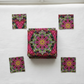 Needle Stars Byzantium Red/Multi quilting cotton by Paula Nadelstern for Benartex – folded fabric stack showing bold jewel-toned kaleidoscopic mandala star print in magenta, hot pink, forest green, yellow, orange, and black. Quilt blocks shown for inspiration. Coordinating fabrics and quilt patterns are available at IraRobi Quilts.