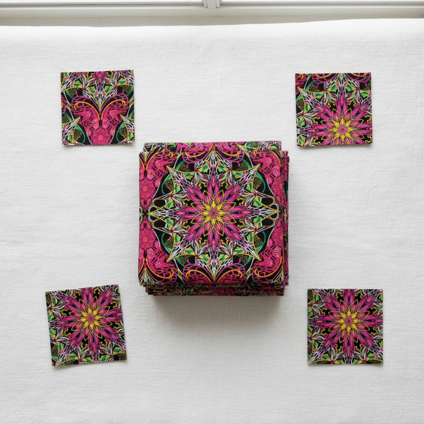 Needle Stars Byzantium Red/Multi quilting cotton by Paula Nadelstern for Benartex – folded fabric stack showing bold jewel-toned kaleidoscopic mandala star print in magenta, hot pink, forest green, yellow, orange, and black. Quilt blocks shown for inspiration. Coordinating fabrics and quilt patterns are available at IraRobi Quilts.