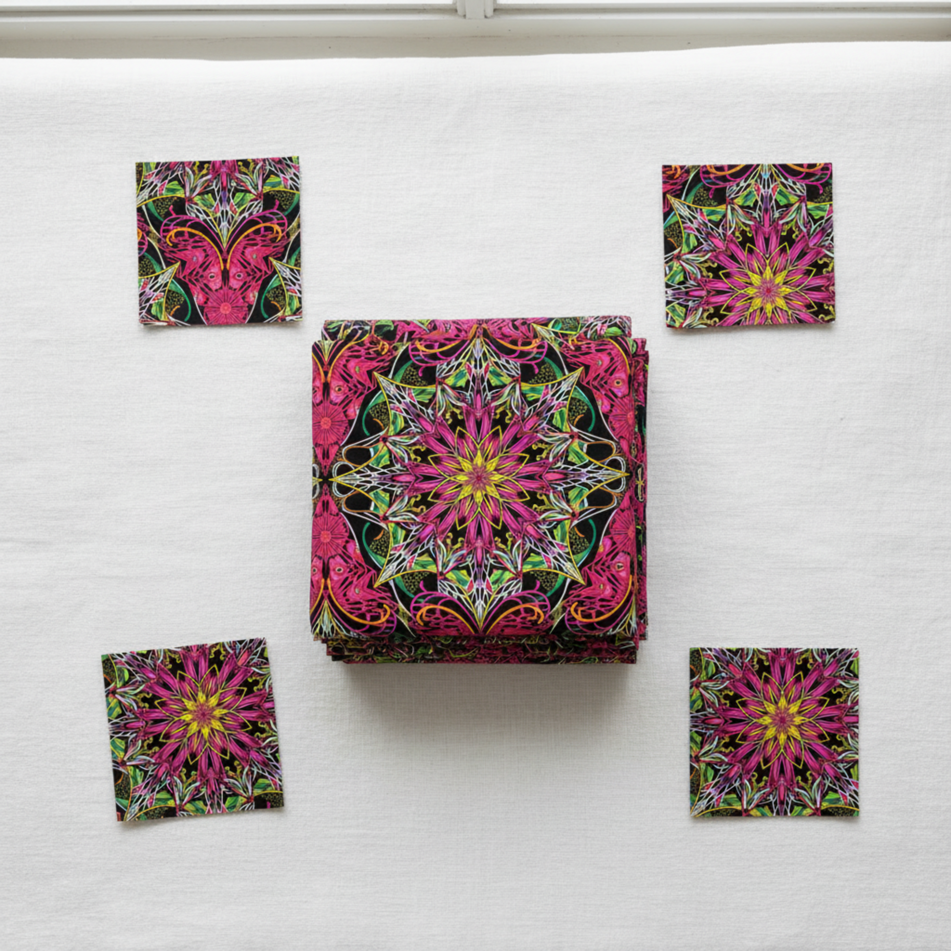 Needle Stars Byzantium Red/Multi quilting cotton by Paula Nadelstern for Benartex – folded fabric stack showing bold jewel-toned kaleidoscopic mandala star print in magenta, hot pink, forest green, yellow, orange, and black. Quilt blocks shown for inspiration. Coordinating fabrics and quilt patterns are available at IraRobi Quilts.