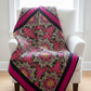 Bold modern medallion quilt featuring a fussy-cut Needle Stars Byzantium Red/Multi center star by Paula Nadelstern for Benartex, with coordinating jewel-tone Interwoven companion fabrics in magenta, green, and black. Quilts shown for inspiration. Coordinating fabrics and quilt patterns are available at IraRobi Quilts.