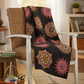Cozy living room quilt made with Needle Stars panel by Paula Nadelstern for Benartex — bold kaleidoscopic starbursts in pink, gold & yellow on black, draped over a farmhouse chair with a sewing basket nearby. The perfect statement quilt for your home! Shop the fabric and download the free "Going Up" pattern. #QuiltLife #NeedleStars #Benartex #KaleidoscopeQuilt #QuiltPanel #HomeDecorQuilt #QuiltInspiration