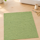 Olive You Net Sage Fabric by Zen Chic for Moda Fabrics, a square swatch laid flat on a wooden table beside a sewing machine, scissors, and cream thread. ⠋