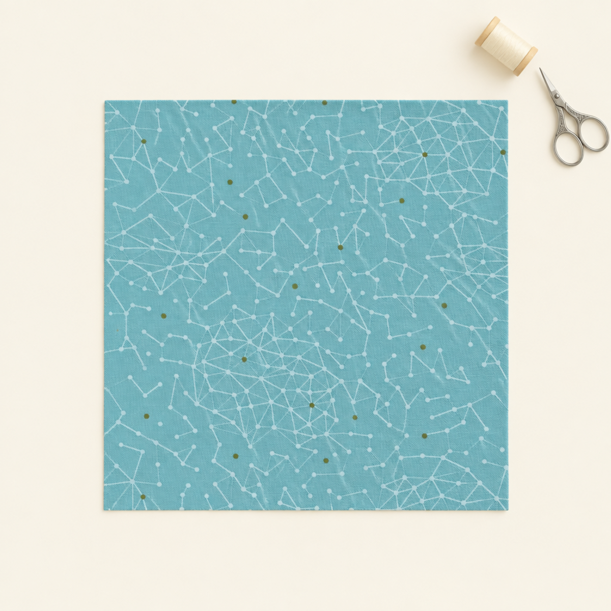 Olive You Net Sky Fabric by Zen Chic for Moda Fabrics, a square swatch laid flat on an ivory background beside cream thread and silver embroidery scissors. ⠋