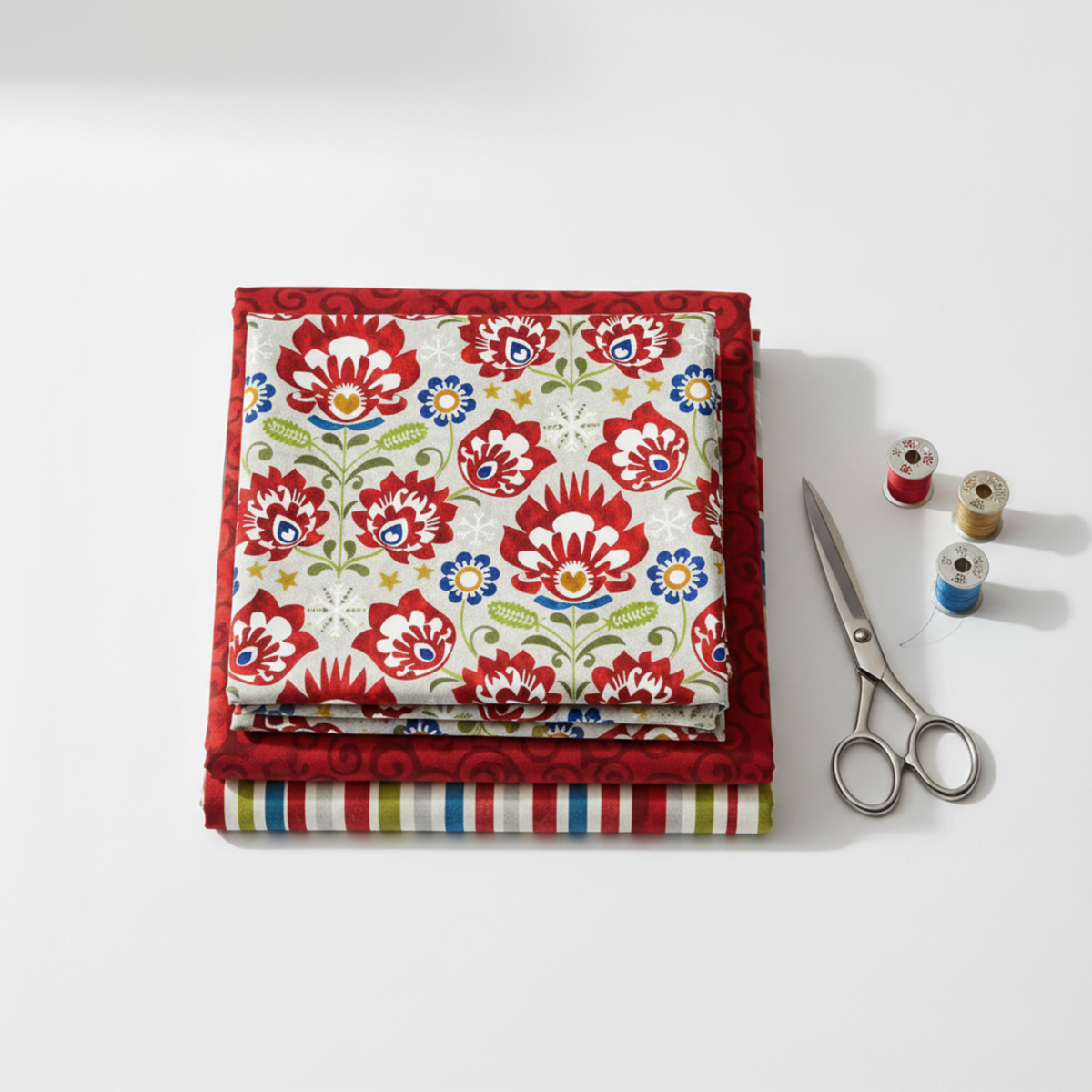 NYSNO New Snow Multicolor Floral quilting cotton by Jason Yenter for In The Beginning Fabrics — folded as hero on a coordinating fabric stack with silver scissors and thread spools on a white surface. Coordinating fabrics and quilt patterns available at IraRobi Quilts