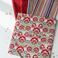 NYSNO New Snow Multicolor Floral quilting cotton by Jason Yenter for In The Beginning Fabrics — vertical flat lay as hero fabric fanned over coordinating fabrics with silver scissors and thread spools, gold snowflake and star confetti on a white surface. Coordinating fabrics and quilt patterns available at IraRobi Quilts.
