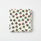 NYSNO New Snow White Holly quilting cotton by Jason Yenter for In The Beginning Fabrics — folded fat quarter on a white surface showing tossed holly leaves in forest green with deep red berry clusters on a soft mottled white ground, 100% cotton, 43–44" wide.