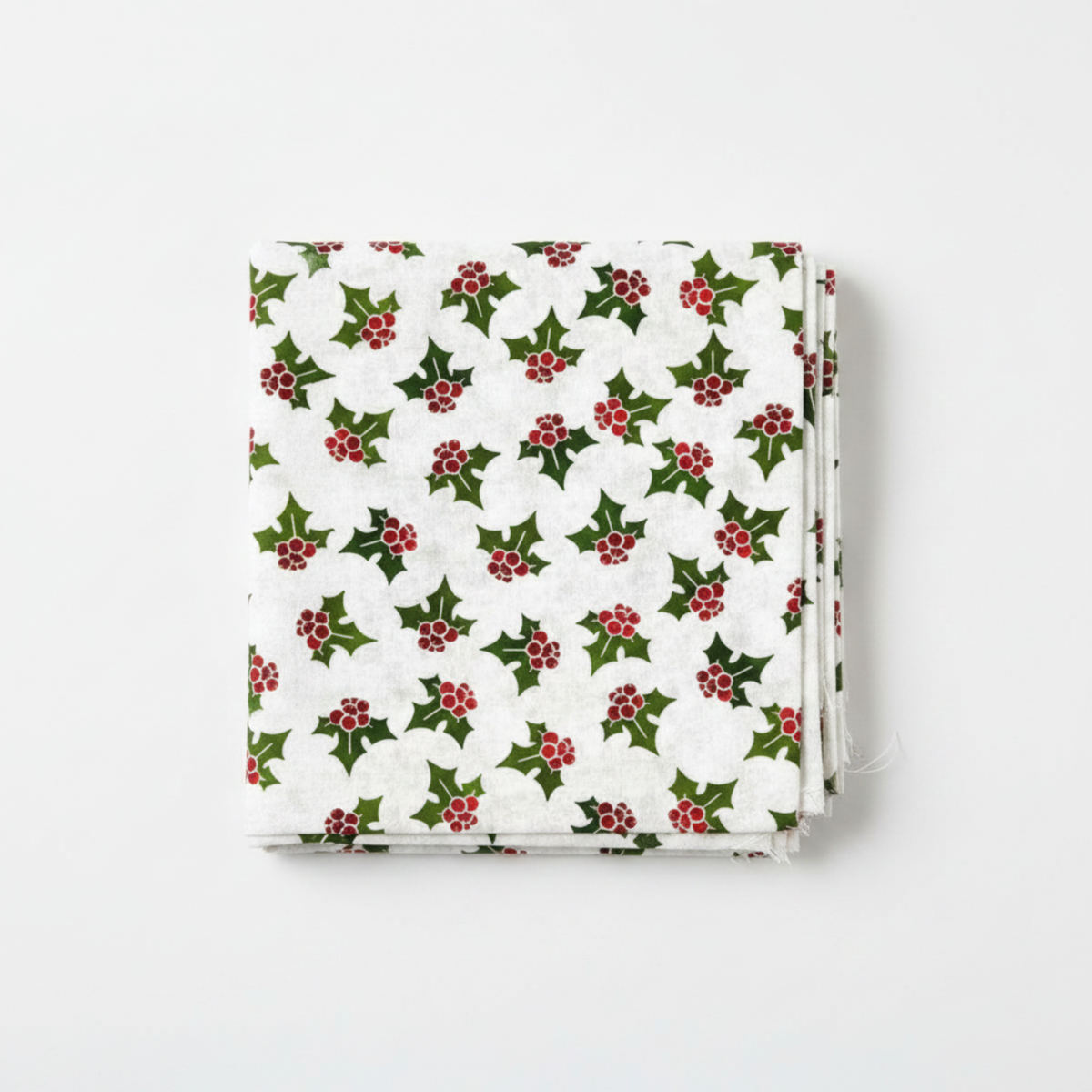 NYSNO New Snow White Holly quilting cotton by Jason Yenter for In The Beginning Fabrics — folded fat quarter on a white surface showing tossed holly leaves in forest green with deep red berry clusters on a soft mottled white ground, 100% cotton, 43–44" wide.