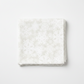 NYSNO New Snow White Snowflakes quilting cotton by Jason Yenter for In The Beginning Fabrics — folded fat quarter on a white surface showing densely scattered white-on-white snowflake silhouettes on a soft mottled ground, tone-on-tone allover print, 100% cotton, 43–44" wide.