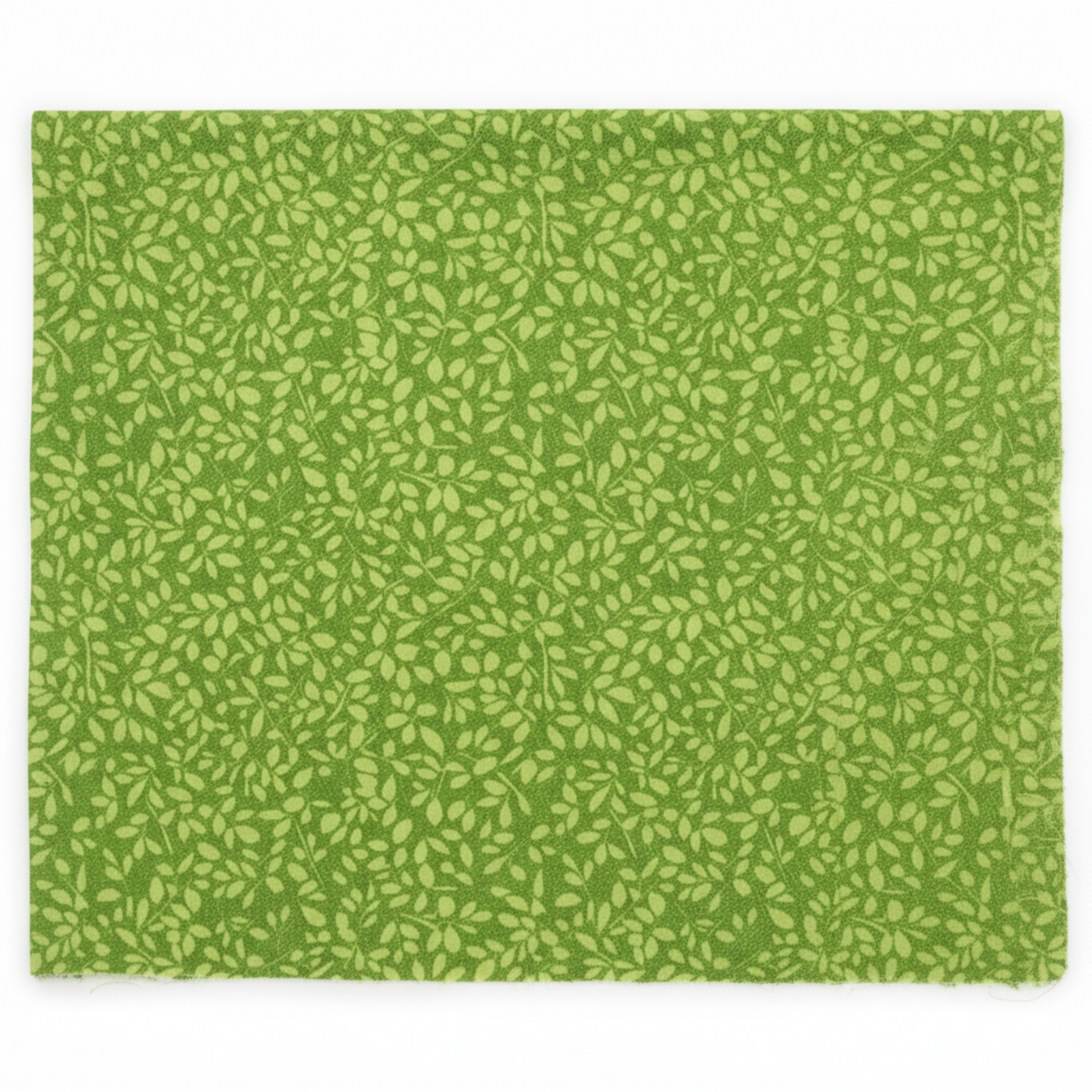 On the Go Leaves Green quilting cotton by Jason Yenter for In The Beginning Fabrics — flat lay showing dense all-over tone-on-tone print of small elongated oval leaves in soft chartreuse-green on a lush grass-green ground, raw cut edges visible, 100% cotton, 43–44" wide.