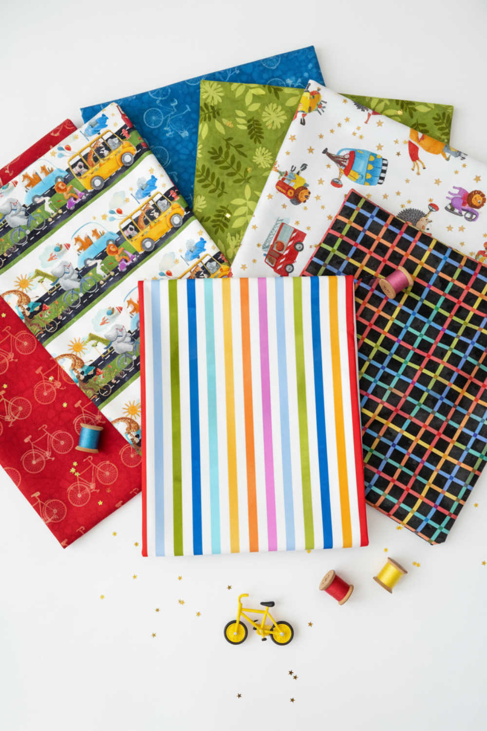 On the Go Stripes Multi quilting cotton by Jason Yenter for In The Beginning Fabrics — vertical Pinterest-style fan spread with the rainbow stripe as the hero, surrounded by coordinating fabrics, gold star confetti, a toy bicycle, and colorful thread spools. Coordinating fabrics and quilt patterns available at IraRobi Quilts.