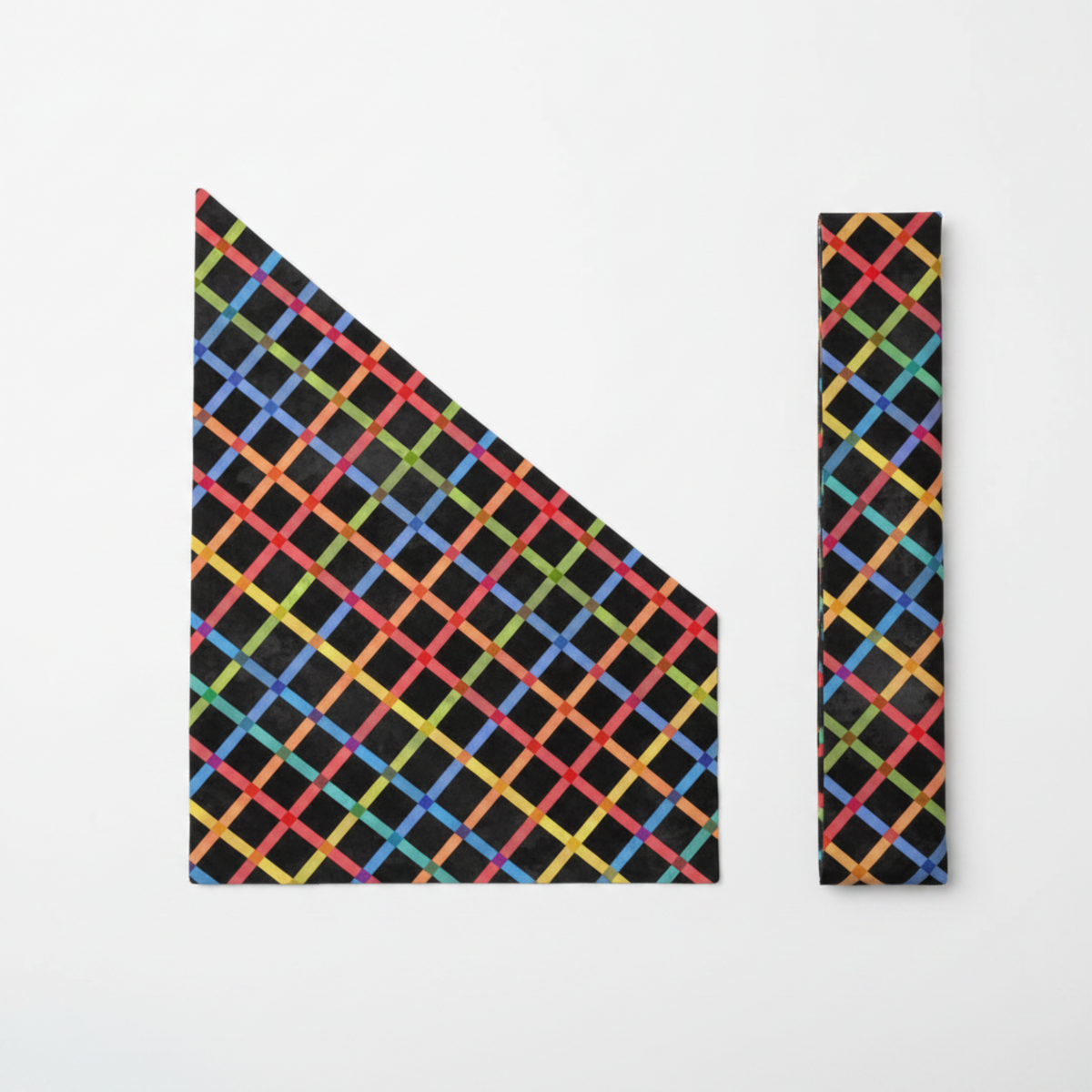 On the Go Plaid Multi quilting cotton by Jason Yenter for In The Beginning Fabrics — flat lay showing fabric cut on the diagonal to reveal the dynamic chevron effect of the rainbow grid, with a folded bias binding strip alongside on a white surface.