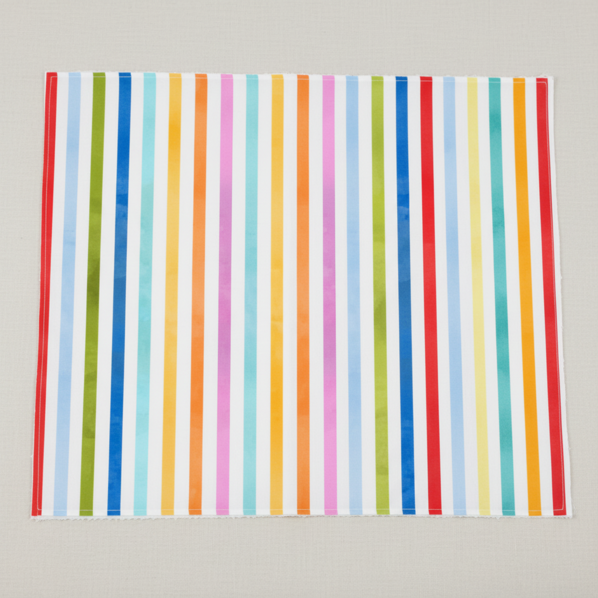 On the Go Stripes Multi quilting cotton by Jason Yenter for In The Beginning Fabrics — close-up flat lay showing crisp vertical rainbow stripes in red, sky blue, grass green, cobalt blue, teal, yellow-green, aqua, orange, and hot pink with subtle watercolor texture on a bright white ground, 100% cotton, 43–44" wide.