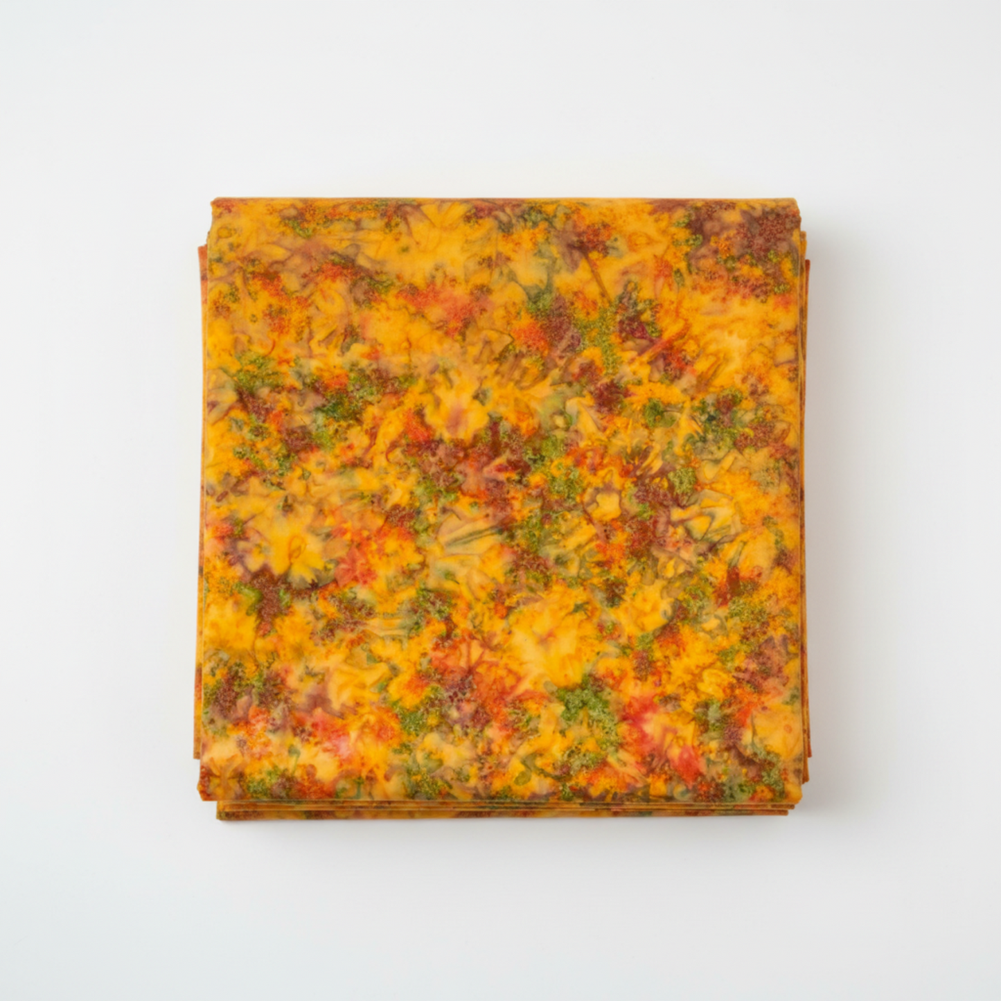 Expressions Batiks Hand-Dyes Orange Multi II quilting cotton fabric by Riley Blake Designs folded into a neat square showing bright luminous golden amber-orange multicolor hand-dyed batik with warm red-orange splashes, olive and moss green accents, and soft lavender-grey hints – a bold autumn harvest focal blender, 100% cotton batik, 43–44" wide