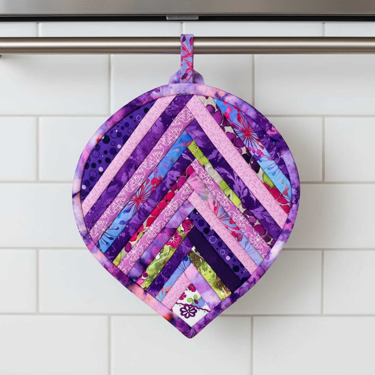 Leaf-Shaped Quilted Hot Pad – Violet Bloom hanging on oven handle, pointed tip down | Handmade by IraRobi Quilts
