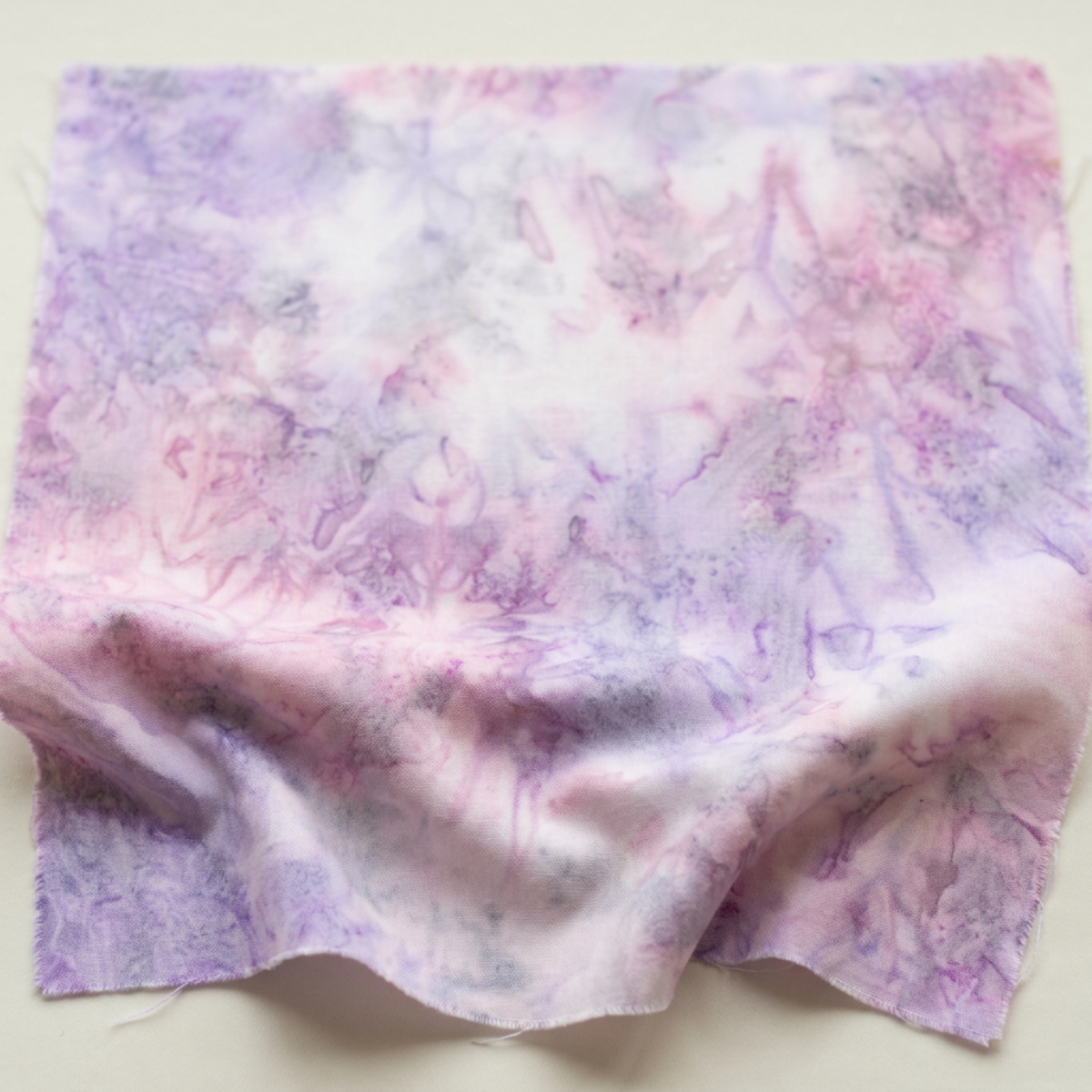 Color Play Mottled Lilac Lustre fabric by Riley Blake Designs, softly draped on a light surface to show its pink, lavender, and creamy white mottled texture.