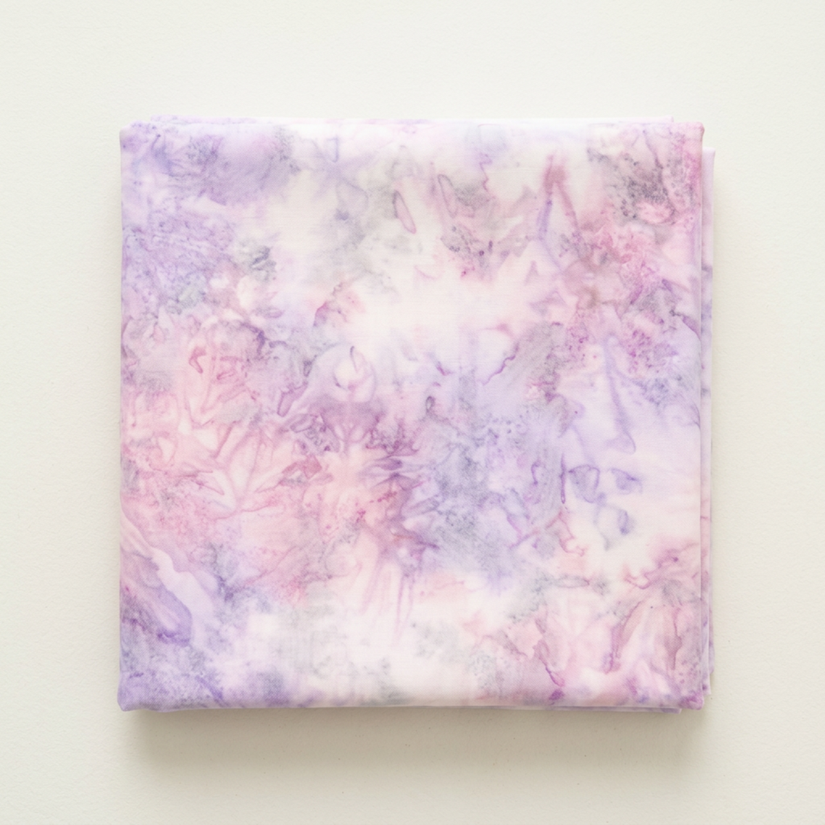 Folded Color Play Mottled Lilac Lustre fabric by Riley Blake Designs on an ivory surface, showing pale pink and lavender mottling.