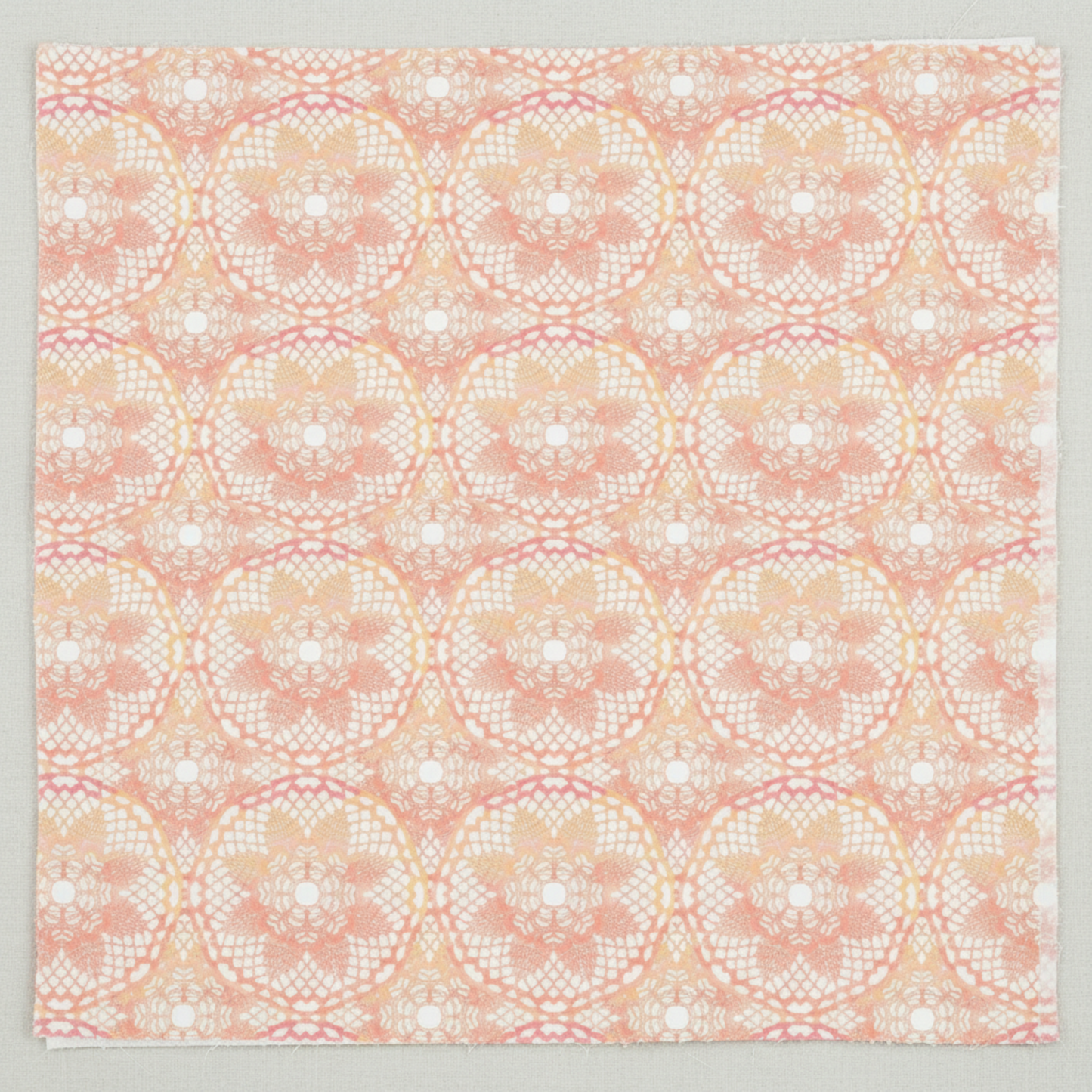 Patricia Coral Lace close-up flat layPatricia Coral Lace 3-Yard Cut quilting cotton by Jason Yenter for In The Beginning Fabrics — close-up flat lay showing overlapping circular lace medallions with intricate lattice diamonds, filigree arcs, and delicate floral centers in soft blush coral, warm peach, and creamy white with rose-pink accents, 100% cotton, 43–44" wide.
