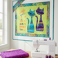PAWsitivity Purple Field quilting cotton by Jason Yenter for In The Beginning Fabrics — work-in-progress ModCat Quilt Pattern by Colourwerx on a design wall in a bright modern sewing room, featuring the Purple Field fabric in the purple cat appliqué alongside teal and yellow coordinating fabrics, with purple and hot pink thread spools, rotary cutter, and fabric scraps on a wooden sewing table. Quilts shown for inspiration feature the ModCat Quilt Pattern by Colourwerx — available at IraRobi Quilt