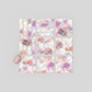 Fire & Ice by Maywood Studio Peach Ice Dye cotton quilting fabric cut into strips and squares arranged in a flat lay with coordinating thread spools on light grey background