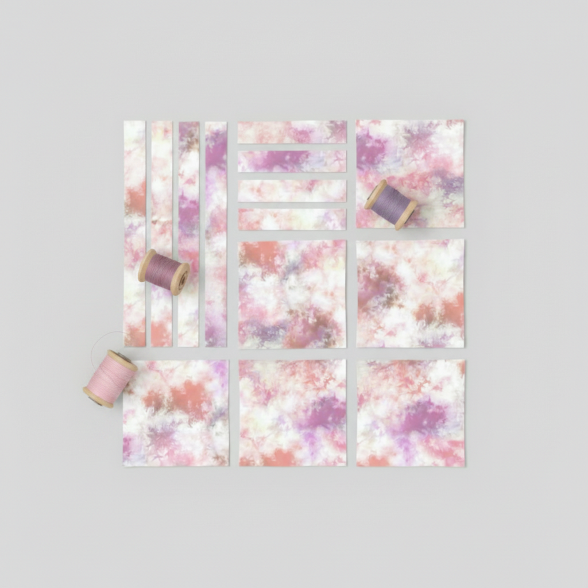 Fire & Ice by Maywood Studio Peach Ice Dye cotton quilting fabric cut into strips and squares arranged in a flat lay with coordinating thread spools on light grey background