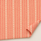 Dandi Duo Peach fabric laid flat with a folded corner, showing its coral stitched-X rows and white starbursts.