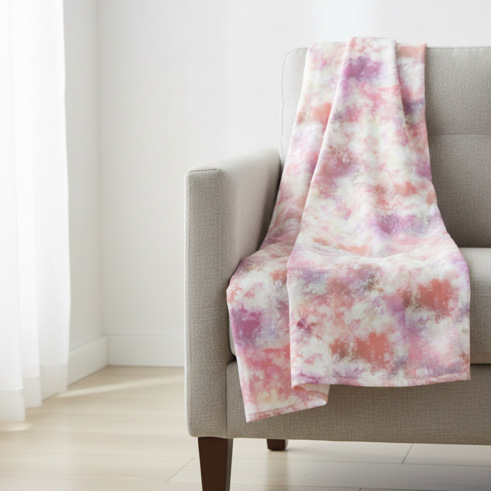 Fire & Ice by Maywood Studio Peach Ice Dye cotton quilting fabric draped over a neutral grey chair in a bright airy room