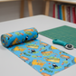 Safari Fun Playful Safari Blue quilting cotton rolled on a bolt with a teal rotary cutter on a green cutting mat — whimsical tigers, leopards, monkeys, and toucans by Terry Runyan for Benartex | IraRobi Quilts