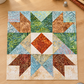 Sunset quilt block from the Windsong Block of the Month program by Wing and a Prayer Design, styled on a sewing table with coordinating Tonga Batiks, thread, clips, a rotary cutter, and thimble. Quilt block shown for inspiration. Coordinating fabrics and quilt patterns are available at IraRobi Quilts.