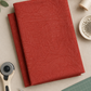 Vertical flat lay of Breezeway Medium Red Palm Patterns fabric surrounded by quilting tools, red and cream thread, scissors, pins, and a cutting mat.